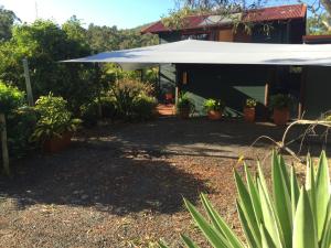 A large white umbrella is in the middle of a yard.